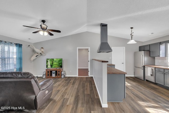 kitchen featuring appliances with stainless steel finishes, island range hood, pendant lighting, butcher block counters, and gray cabinetry