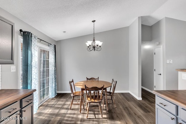 dining room featuring a chandelier, a textured ceiling, and dark hardwood / wood-style flooring