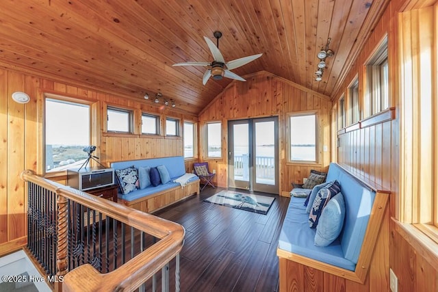 living room with lofted ceiling, wood ceiling, and wooden walls