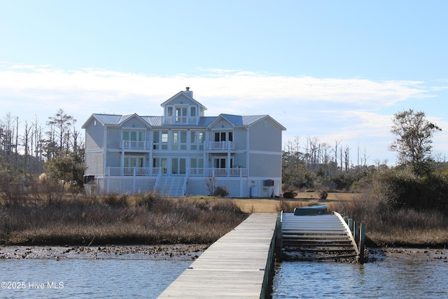 view of dock with a balcony and a water view