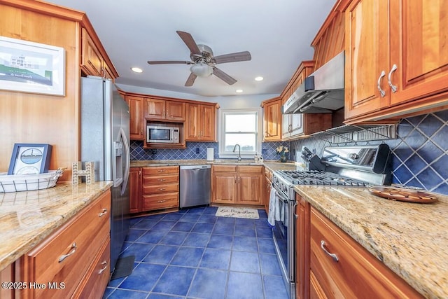 kitchen with appliances with stainless steel finishes, range hood, sink, and light stone countertops