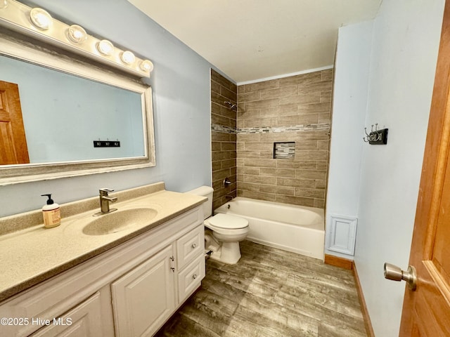 full bathroom with hardwood / wood-style flooring, tiled shower / bath, vanity, and toilet