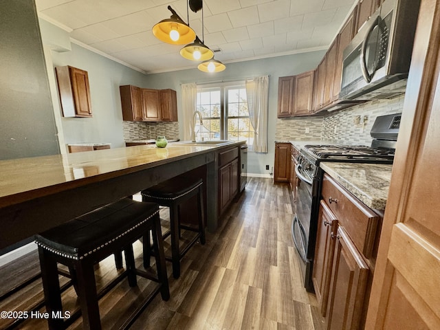 kitchen featuring pendant lighting, sink, crown molding, dark wood-type flooring, and gas range