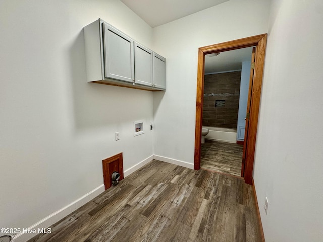 laundry room featuring cabinets, electric dryer hookup, dark wood-type flooring, and washer hookup