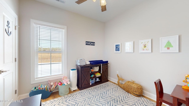 playroom with light hardwood / wood-style flooring and ceiling fan