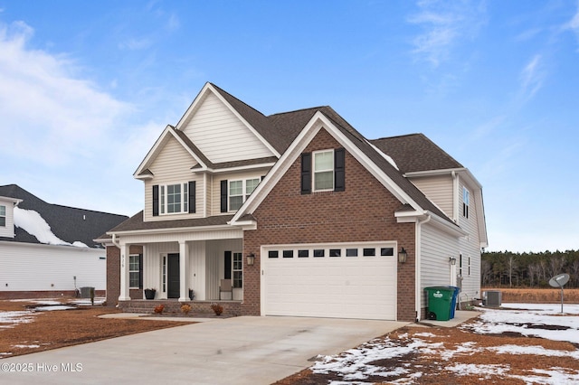 craftsman-style home with a garage, a porch, and central air condition unit