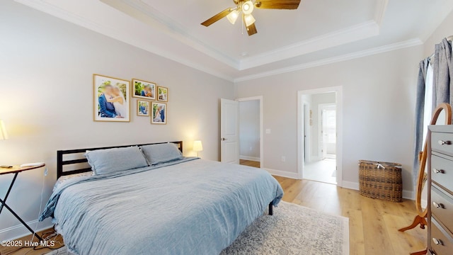 bedroom featuring crown molding, ceiling fan, a tray ceiling, and light wood-type flooring