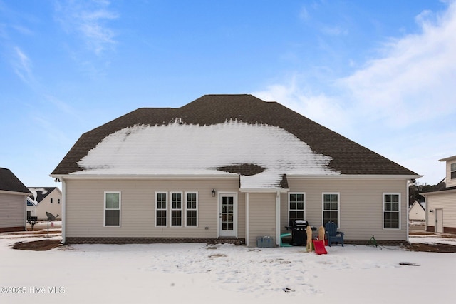 view of snow covered rear of property