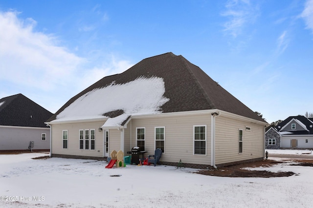 view of snow covered back of property