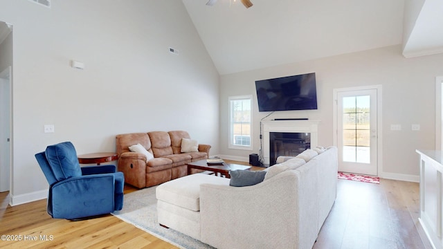 living room with ceiling fan, wood-type flooring, and high vaulted ceiling