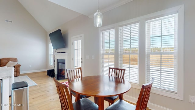 dining space with lofted ceiling and light wood-type flooring