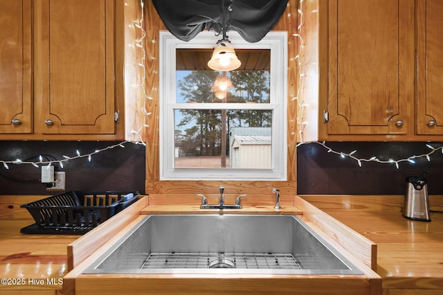 kitchen featuring tasteful backsplash, sink, and butcher block countertops