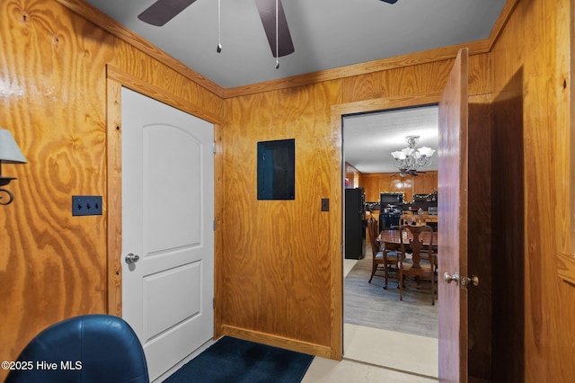 entryway featuring ceiling fan, wooden walls, and electric panel