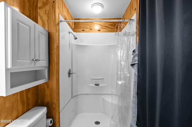 bathroom with toilet and a shower with shower curtain