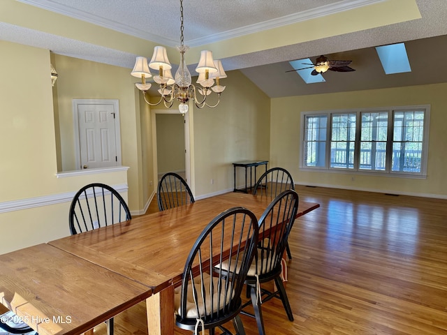 dining area with a textured ceiling, ceiling fan with notable chandelier, wood finished floors, baseboards, and ornamental molding