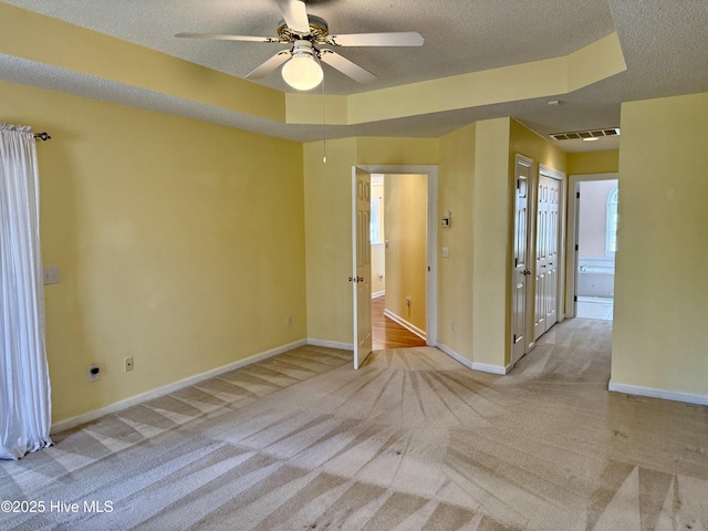 carpeted spare room with baseboards, visible vents, and a textured ceiling