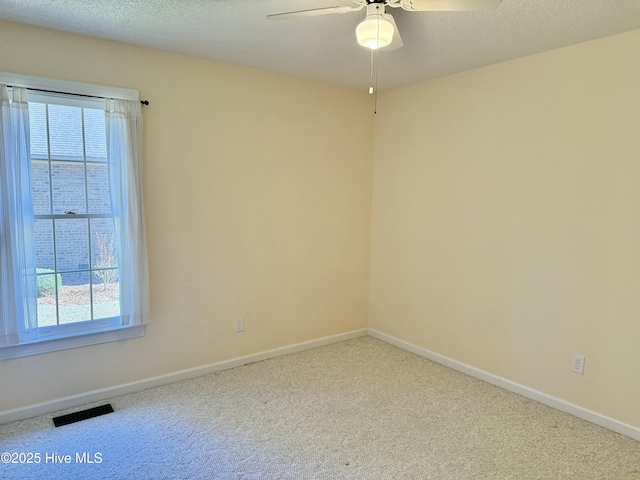 empty room with plenty of natural light, carpet flooring, and visible vents