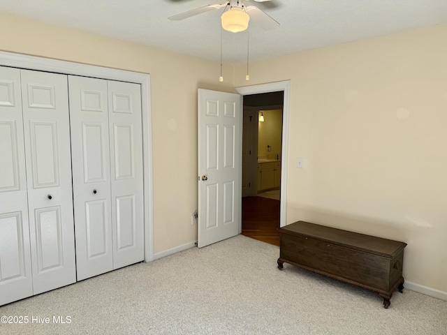 carpeted bedroom with a ceiling fan, baseboards, and a closet