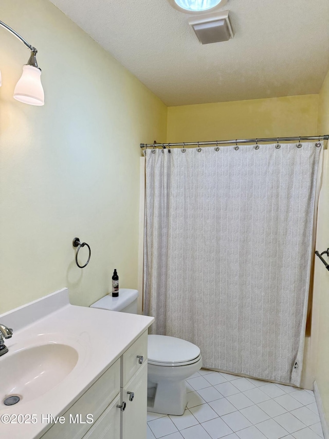 bathroom featuring a textured ceiling, curtained shower, toilet, vanity, and tile patterned floors