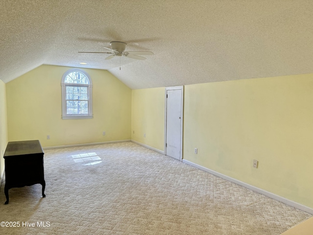 bonus room featuring carpet, vaulted ceiling, and a textured ceiling