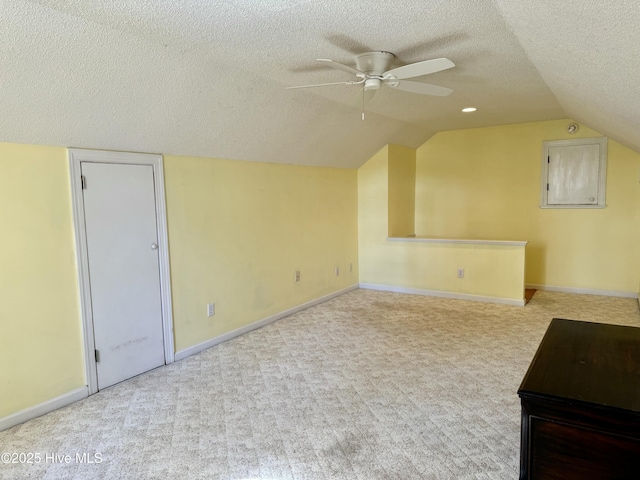 bonus room featuring a textured ceiling, ceiling fan, carpet flooring, and baseboards