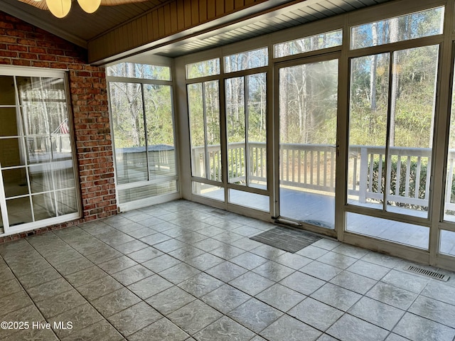 unfurnished sunroom with lofted ceiling and visible vents