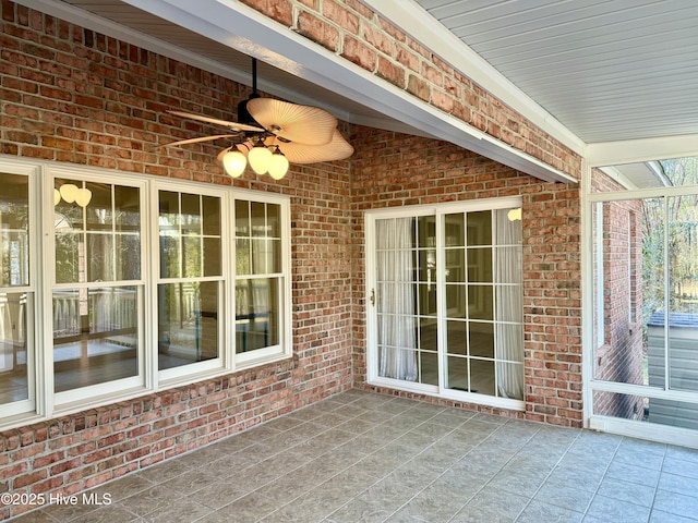 unfurnished sunroom with ceiling fan