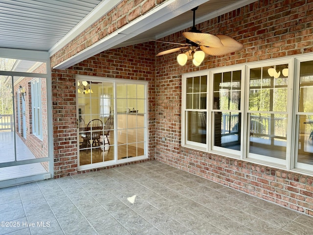 unfurnished sunroom featuring ceiling fan