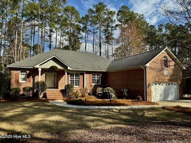 view of front of home with a garage, driveway, a shingled roof, and brick siding