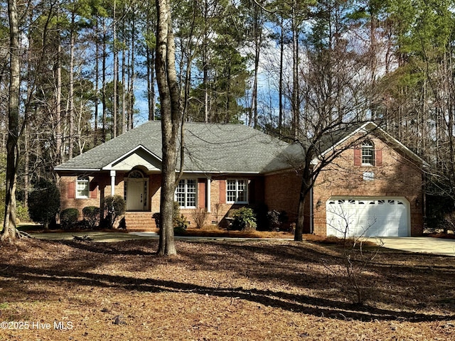 single story home with concrete driveway, brick siding, and a shingled roof