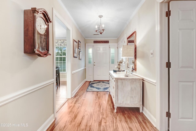 interior space with crown molding, a chandelier, and light hardwood / wood-style flooring