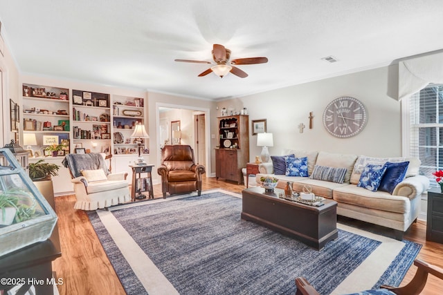 living room featuring hardwood / wood-style floors, crown molding, and ceiling fan