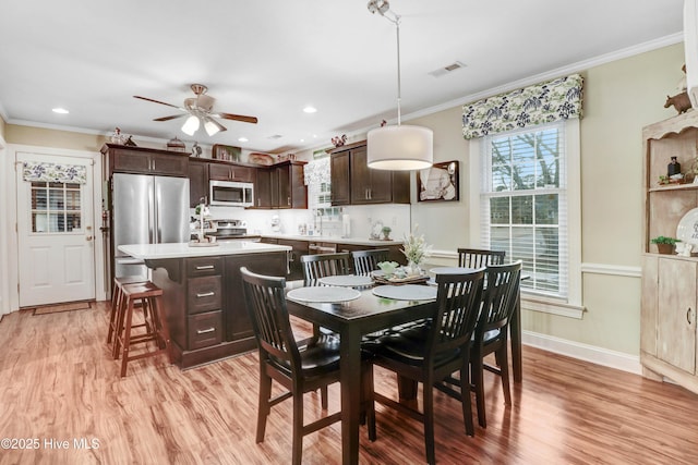 dining area featuring ornamental molding, ceiling fan, and light hardwood / wood-style floors