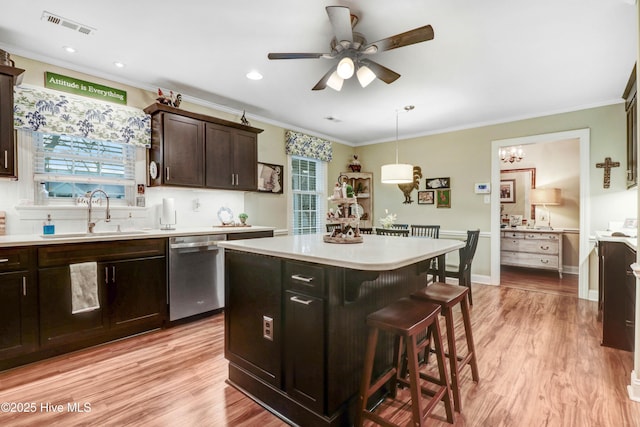 kitchen with a kitchen island, pendant lighting, dishwasher, sink, and a breakfast bar area