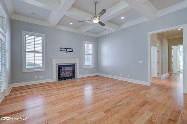 unfurnished living room with beam ceiling, a healthy amount of sunlight, and light wood-type flooring