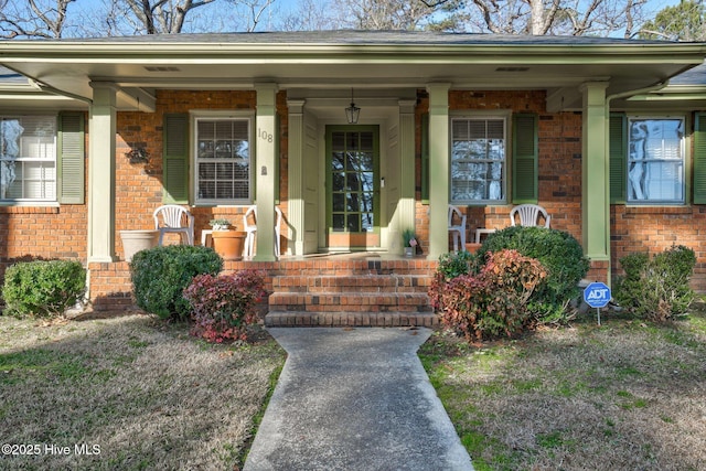 view of exterior entry featuring covered porch