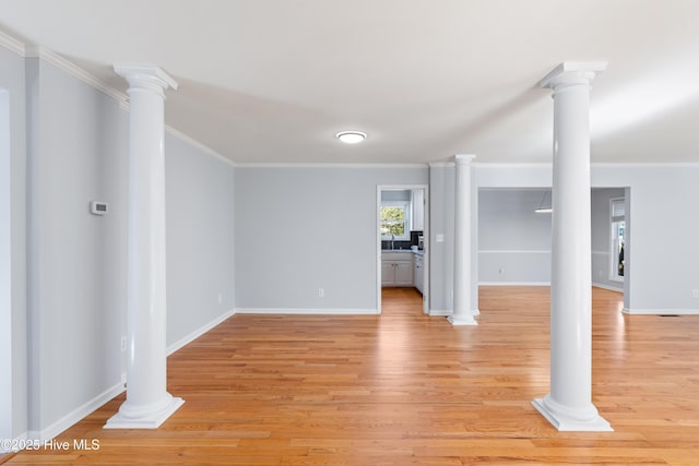 unfurnished living room featuring crown molding, light hardwood / wood-style floors, and ornate columns