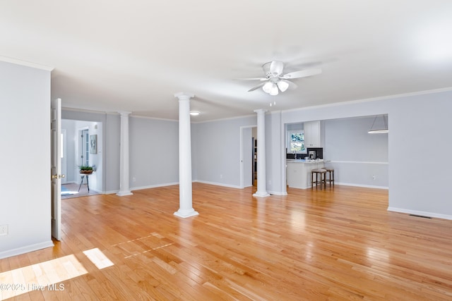 unfurnished living room featuring decorative columns, ornamental molding, ceiling fan, and light hardwood / wood-style floors