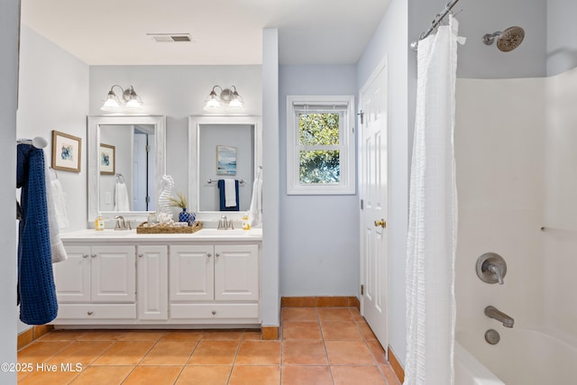 bathroom with tile patterned floors, shower / bath combo with shower curtain, and vanity