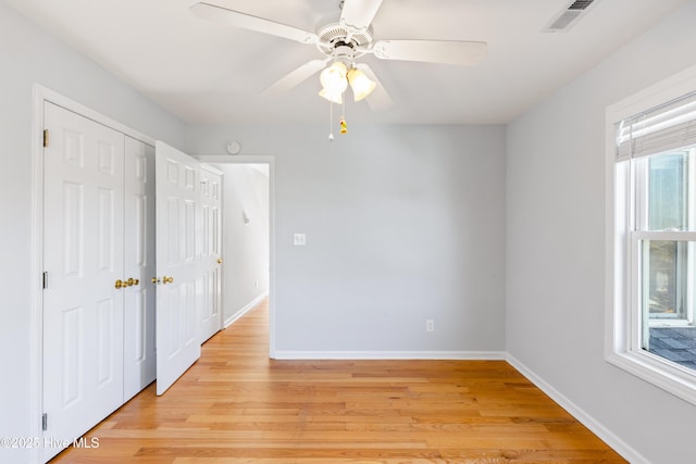 empty room with ceiling fan and light hardwood / wood-style floors