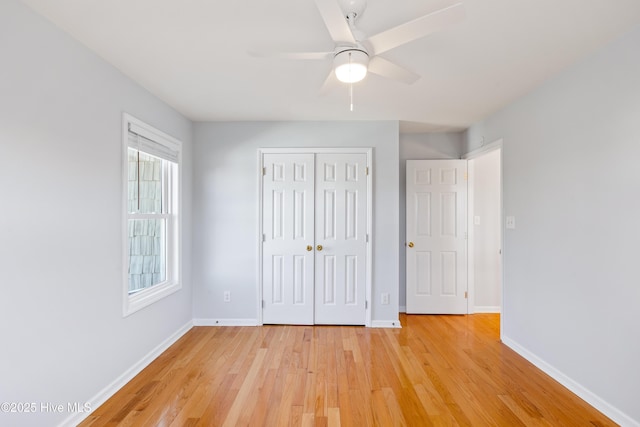 unfurnished bedroom with light hardwood / wood-style floors, a closet, and ceiling fan