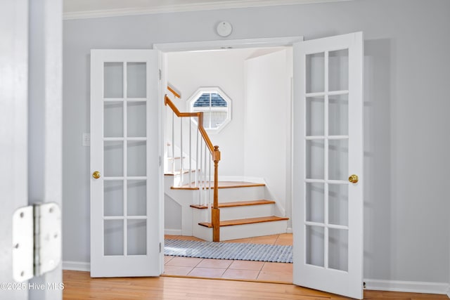 staircase featuring crown molding, hardwood / wood-style floors, and french doors