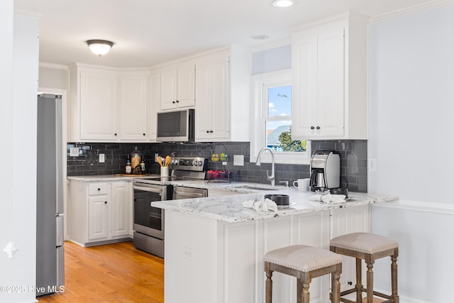 kitchen with sink, white cabinets, and appliances with stainless steel finishes