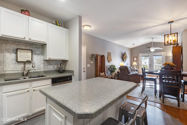 kitchen featuring white cabinetry, lofted ceiling, sink, and decorative backsplash