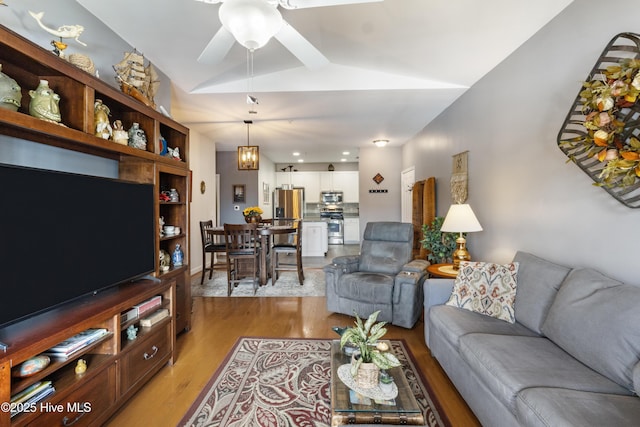 living room with ceiling fan, lofted ceiling, and light wood-type flooring