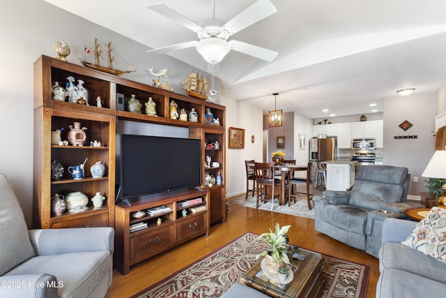 living room with vaulted ceiling, ceiling fan, and light hardwood / wood-style floors