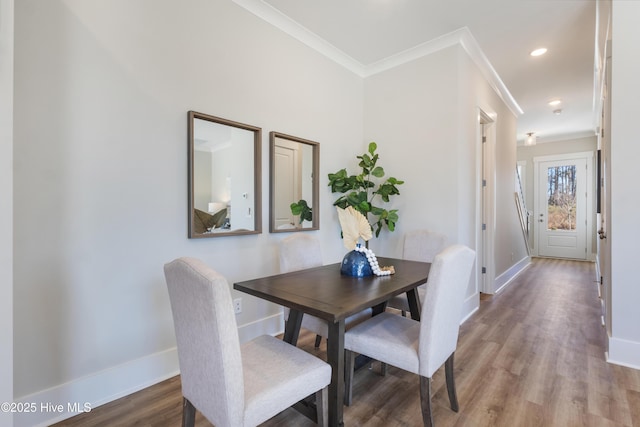 dining space with hardwood / wood-style flooring and ornamental molding