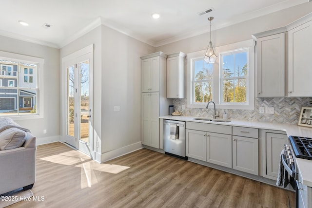 kitchen with pendant lighting, stainless steel appliances, crown molding, and sink