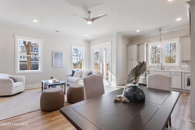 dining area featuring crown molding, plenty of natural light, and light hardwood / wood-style floors