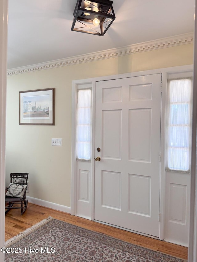 foyer featuring crown molding and hardwood / wood-style flooring